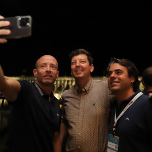 Participantes tiram fotos em frente à barragem iluminada